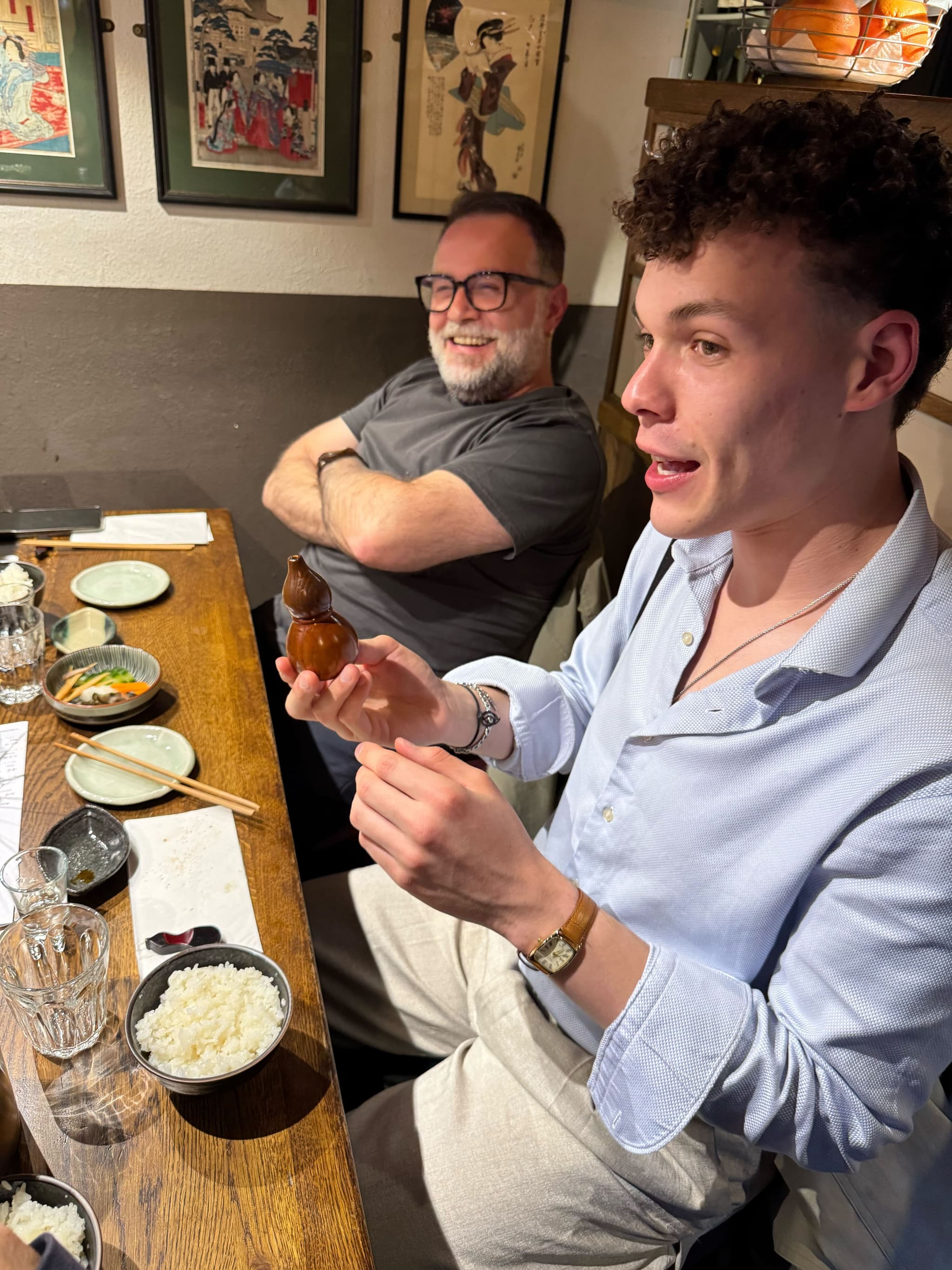 Sharing a laugh at a tiny izakaya—soya gourd in hand